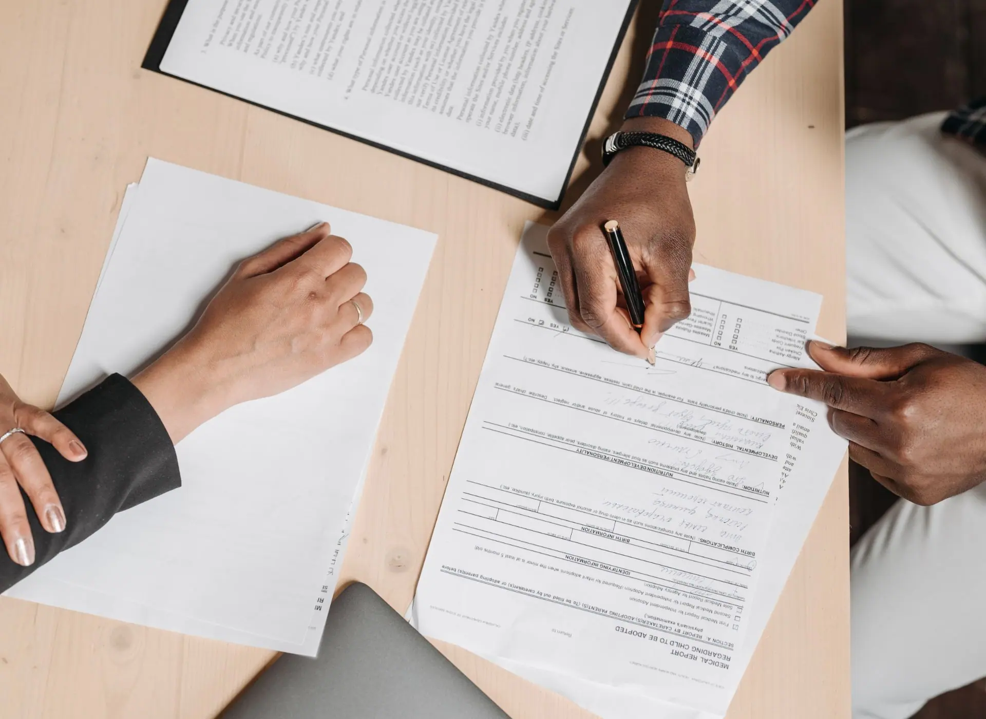 Dos personas escribiendo en documentos