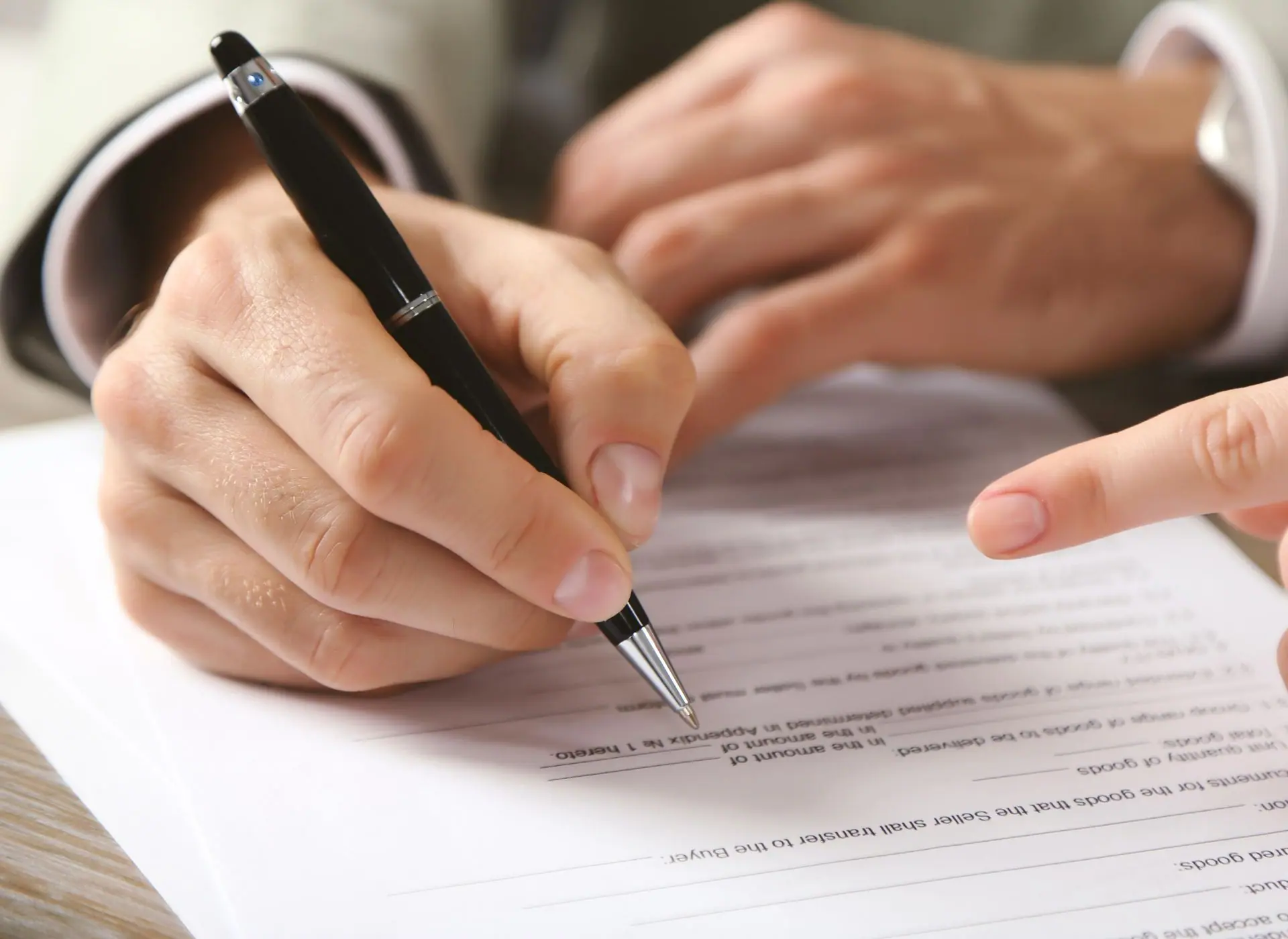 Persona firmando documentos con pluma